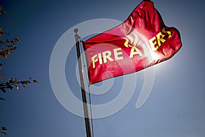 Flag reading `Fire Alert` in wind against blue sky photo